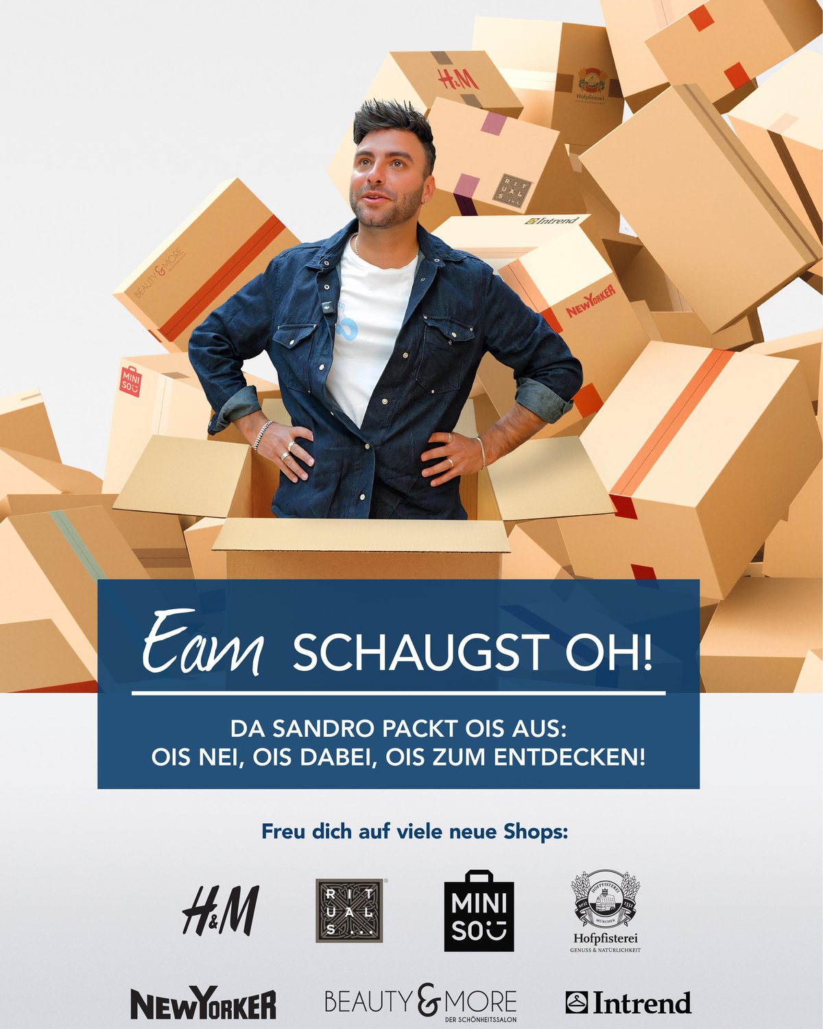 Sandro steht in einem geöffneten Karton, umgeben von Boxen mit den Logos der neuen OEZ-Stores